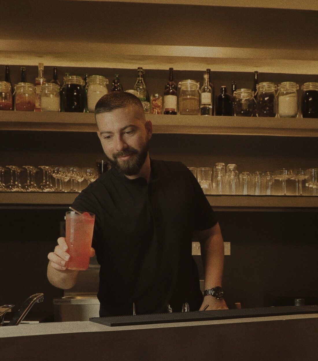 Enzo Ruiz serving a cocktail behind the bar at Stillroom
